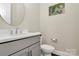 Well-lit powder room featuring a round mirror and modern fixtures at 5129 Whitman Ave, Matthews, NC 28105