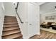 Elegant staircase with wood treads and white risers, complemented by a cozy living room view at 5129 Whitman Ave, Matthews, NC 28105