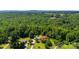 Aerial view of property surrounded by lush greenery, featuring mature trees, manicured lawn, a barn, and multiple outbuildings at 5425 Creek Run Ct, Kings Mountain, NC 28086