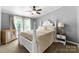 A four-poster bed is the focal point of this bright bedroom with a ceiling fan at 5425 Creek Run Ct, Kings Mountain, NC 28086