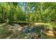 Scenic view of a tranquil creek flowing through a lush, wooded area, enhancing the property's natural beauty at 5425 Creek Run Ct, Kings Mountain, NC 28086