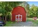 Red barn-style outbuilding features white trim, double doors, and a gated entryway at 5425 Creek Run Ct, Kings Mountain, NC 28086
