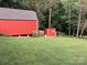 Property featuring a rustic red barn and fenced chicken coop surrounded by lush trees at 5425 Creek Run Ct, Kings Mountain, NC 28086