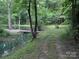 Scenic view of a pond with a small wooden bridge surrounded by lush greenery at 5425 Creek Run Ct, Kings Mountain, NC 28086