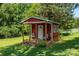 Cozy red shed with a charming porch and seating, nestled in a lush, green yard at 5425 Creek Run Ct, Kings Mountain, NC 28086