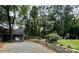 Large backyard featuring a stone wall, mature trees, playset, and a charming guest house at 5916 Indian Brook Dr, Matthews, NC 28104