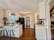 Eat-in kitchen with white cabinetry, a black refrigerator and stove, and hardwood floors at 5916 Indian Brook Dr, Matthews, NC 28104