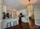 Cozy eat-in kitchen features white cabinets, stainless appliances, pendant lighting and hardwood flooring at 5916 Indian Brook Dr, Matthews, NC 28104