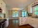 Bright kitchen with white cabinets, and hardwood floors adjoining dining area with a bay window at 5916 Indian Brook Dr, Matthews, NC 28104