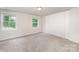 Bright bedroom features neutral carpet, natural light from two windows, and a closet for ample storage at 7008 Wannamaker Ln, Charlotte, NC 28226