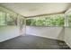 The sunroom with white-paneled walls features abundant light and screened windows overlooking lush greenery at 7008 Wannamaker Ln, Charlotte, NC 28226
