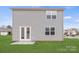 A view of the home's rear exterior featuring new vinyl siding and a well maintained lawn at 707 Olde England Dr, Lincolnton, NC 28092