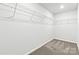 Walk-in closet with neutral carpet, hanging wire shelving, and bright overhead lighting at 707 Olde England Dr, Lincolnton, NC 28092