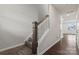 Carpeted staircase featuring wood handrail that complements the hardwood flooring in the home's entryway at 707 Olde England Dr, Lincolnton, NC 28092