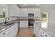 Bright kitchen features granite countertops, stainless steel appliances, white cabinets and an island with extra storage at 7311 Jerimoth Dr, Charlotte, NC 28215