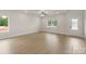 Bright living room featuring light wood floors, white walls, and large windows offering a clean and spacious ambiance at 7311 Jerimoth Dr, Charlotte, NC 28215