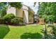 View of the backyard with lush lawn, a deck, mature trees, and a garden at 7321 Harrisonwoods Pl, Charlotte, NC 28270