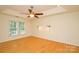 Spacious bedroom with wood floors, a ceiling fan, and two windows offering ample natural light at 7321 Harrisonwoods Pl, Charlotte, NC 28270