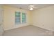 Cozy bedroom with carpeted floors, a ceiling fan, and two windows that bring in natural light at 7321 Harrisonwoods Pl, Charlotte, NC 28270