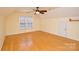 This spacious bedroom features hardwood floors, a ceiling fan, and natural light from the windows at 7321 Harrisonwoods Pl, Charlotte, NC 28270