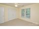 Bright bedroom features carpeted floors, a ceiling fan, and two windows offering natural light at 7321 Harrisonwoods Pl, Charlotte, NC 28270