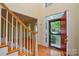 Elegant foyer featuring hardwood floors, a staircase with wooden railings, and a decorative doorway at 7321 Harrisonwoods Pl, Charlotte, NC 28270