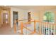 Upstairs hallway with wood and white railing, leading to bedrooms and a bathroom; a large arched window provides natural light at 7321 Harrisonwoods Pl, Charlotte, NC 28270