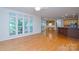 Living area with large windows and hardwood floors opens to the kitchen and outdoor deck at 7321 Harrisonwoods Pl, Charlotte, NC 28270