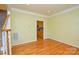 Open living space featuring hardwood floors, neutral walls, and a glimpse of the kitchen at 7321 Harrisonwoods Pl, Charlotte, NC 28270