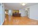 Open concept living area with hardwood floors that connects to the kitchen and staircase at 7321 Harrisonwoods Pl, Charlotte, NC 28270