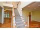 Spacious foyer with hardwood floors, a carpeted staircase, and views into the living spaces at 7321 Harrisonwoods Pl, Charlotte, NC 28270
