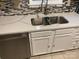 A bright kitchen featuring a modern stainless steel sink, quartz countertops, and white cabinetry at 7401 Merrily Ln, Charlotte, NC 28214