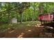 The property featuring a wooden deck, storage shed and lush green space surrounded by tall trees at 8002 Kingston Dr, Waxhaw, NC 28173
