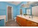 Blue bathroom with double vanity, large mirror, tile flooring, and view into walk in closet at 8002 Kingston Dr, Waxhaw, NC 28173