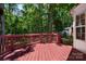 Wooden deck with red painted railings provides view into wooded backyard at 8002 Kingston Dr, Waxhaw, NC 28173