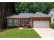 Charming brick home with lush green lawn, complemented by mature trees and a two-car garage at 8002 Kingston Dr, Waxhaw, NC 28173