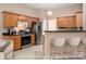 Open kitchen with wood cabinets, stainless steel appliances and breakfast bar with modern seating at 8002 Kingston Dr, Waxhaw, NC 28173