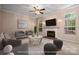 Bright living room with a ceiling fan, a cozy fireplace, and stylish modern furniture at 8002 Kingston Dr, Waxhaw, NC 28173