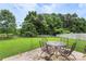 The spacious backyard boasts a lush lawn, mature trees, and a patio set for outdoor entertaining at 8904 Gerald Dr, Charlotte, NC 28217