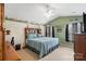 This bedroom features a light green accent wall, a ceiling fan, and a large comfy bed at 8904 Gerald Dr, Charlotte, NC 28217