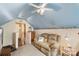 Cozy bonus room with a love seat, carpeted floor, ceiling fan, and stairway to the second level at 8904 Gerald Dr, Charlotte, NC 28217