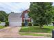 Inviting home with blue door and shutters, red brick, light grey siding, and 2-car attached garage at 8904 Gerald Dr, Charlotte, NC 28217