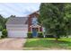 Attractive two-story home with brick accents, blue shutters, an attached 2-car garage, and manicured landscaping at 8904 Gerald Dr, Charlotte, NC 28217