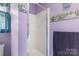 Shower with glass door located in the purple-painted bathroom at 8904 Gerald Dr, Charlotte, NC 28217