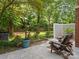 Charming backyard patio with seating, lush greenery, and a brick chimney creating an inviting outdoor space at 9473 Kings Falls Dr, Charlotte, NC 28210