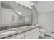 Bathroom featuring dual sinks, granite countertops, a large mirror, and a shower with patterned backsplash at 9473 Kings Falls Dr, Charlotte, NC 28210