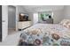 Bright bedroom features a floral-patterned bedspread and a dedicated workspace with a desk and natural light at 9473 Kings Falls Dr, Charlotte, NC 28210