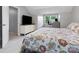 Bright bedroom features a floral-patterned bedspread and a dedicated workspace with a desk and natural light at 9473 Kings Falls Dr, Charlotte, NC 28210