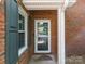 Exterior front door made of brick and a storm door, offering curb appeal at 9473 Kings Falls Dr, Charlotte, NC 28210