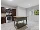 Modern kitchen featuring stainless steel appliances, central island, and white double door for easy pantry access at 9473 Kings Falls Dr, Charlotte, NC 28210